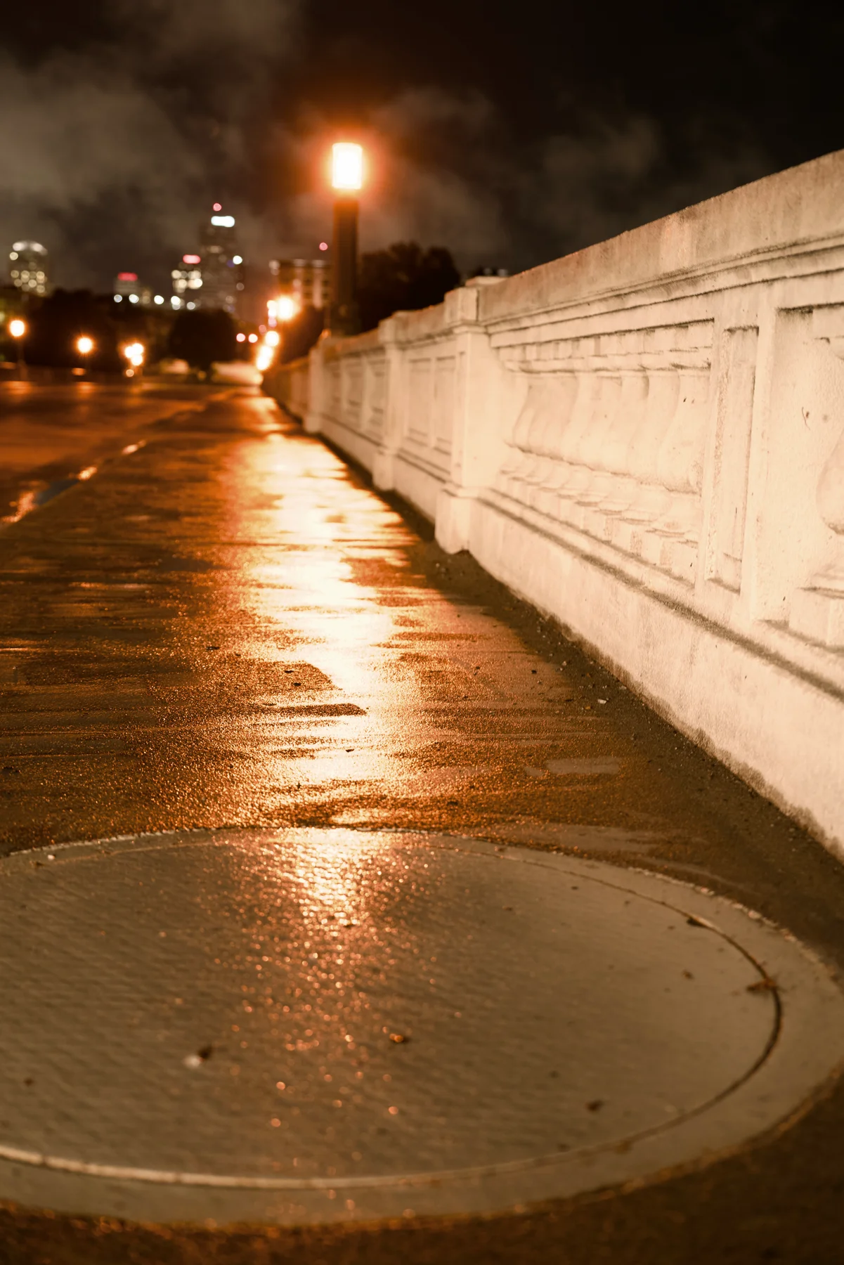 Warm light reflected on a rain-soaked city walkway, photographed by William Keeble